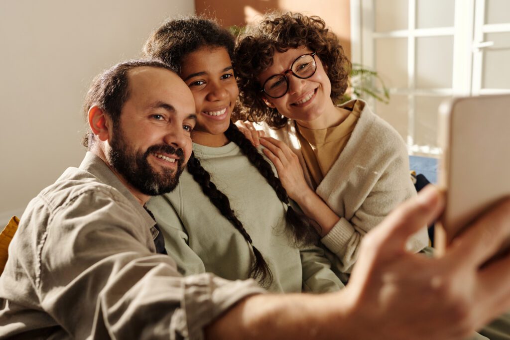 Happy family making selfie portrait with adopted girl